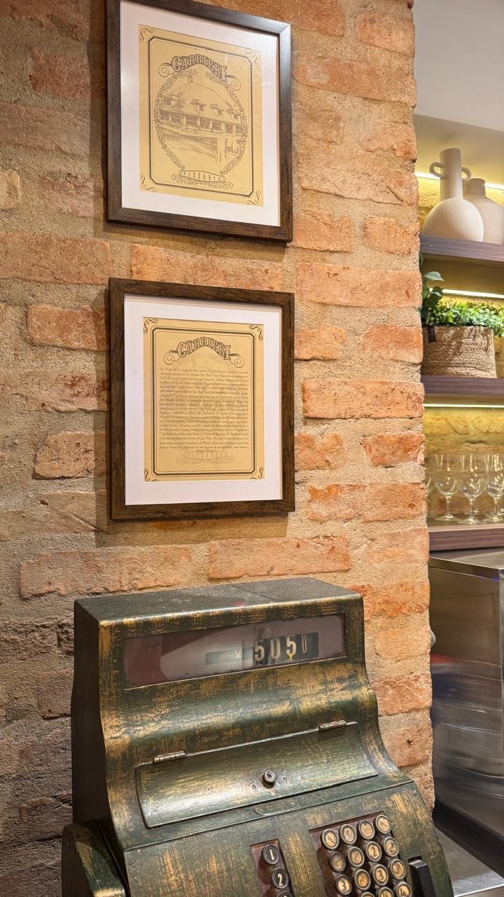 Decoração interna da Carrieri Pizzeria - Caixa registradora antiga e quadros.